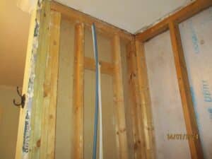 Mold remediation in progress on wooden beams and insulation removal.